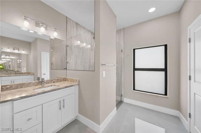 bathroom with tile patterned floors, vanity, and a shower with door