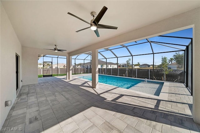 view of pool featuring glass enclosure, ceiling fan, and a patio area