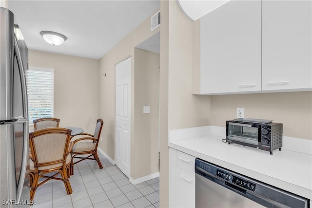 kitchen featuring light tile patterned floors, white cabinetry, and appliances with stainless steel finishes