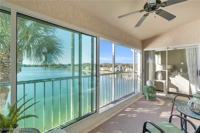 sunroom / solarium featuring a water view, ceiling fan, and lofted ceiling