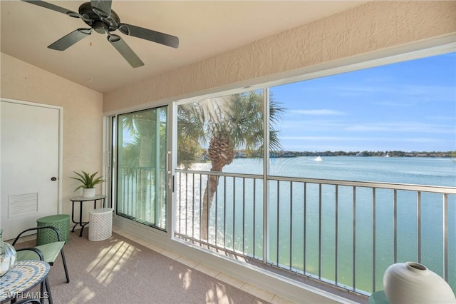 sunroom featuring a water view, vaulted ceiling, and ceiling fan