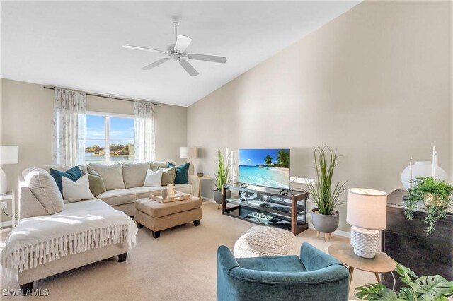 carpeted living room with ceiling fan and vaulted ceiling