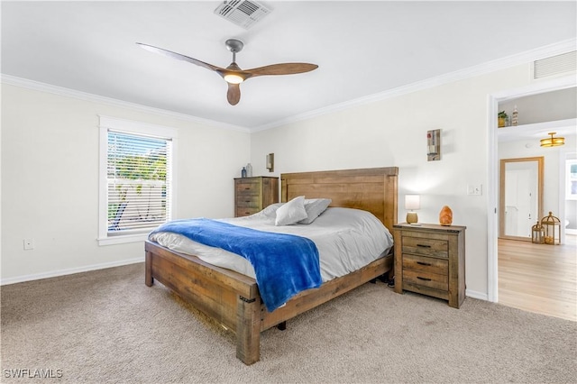 bedroom featuring ceiling fan, light colored carpet, and crown molding