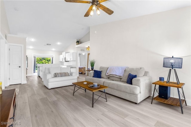 living room with ceiling fan, light hardwood / wood-style floors, and lofted ceiling