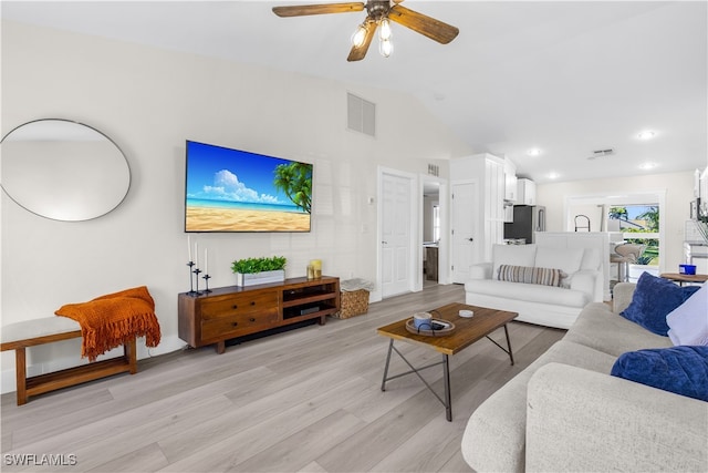 living room featuring light wood-type flooring, vaulted ceiling, and ceiling fan