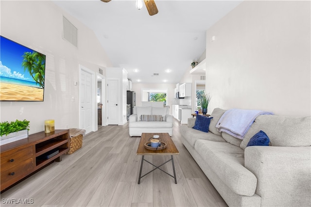 living room featuring ceiling fan, light hardwood / wood-style flooring, and lofted ceiling