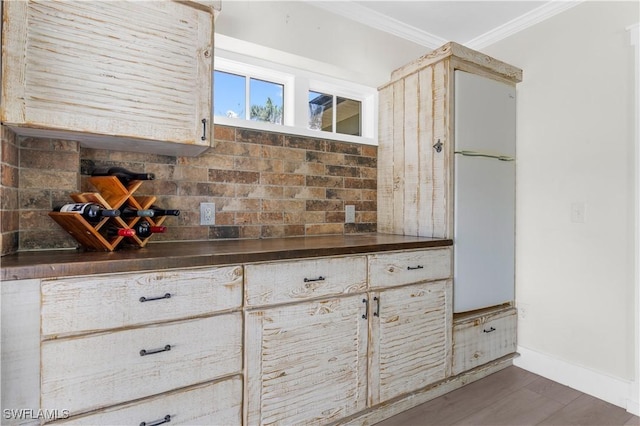 interior details with hardwood / wood-style floors, decorative backsplash, and ornamental molding