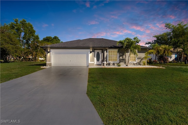 ranch-style home featuring a garage and a yard