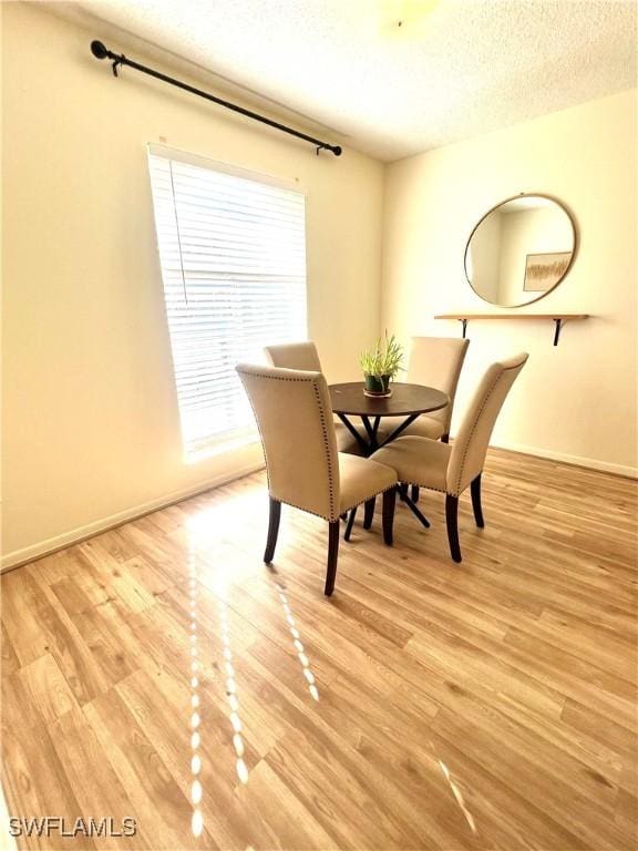 unfurnished dining area featuring a textured ceiling and light wood-type flooring