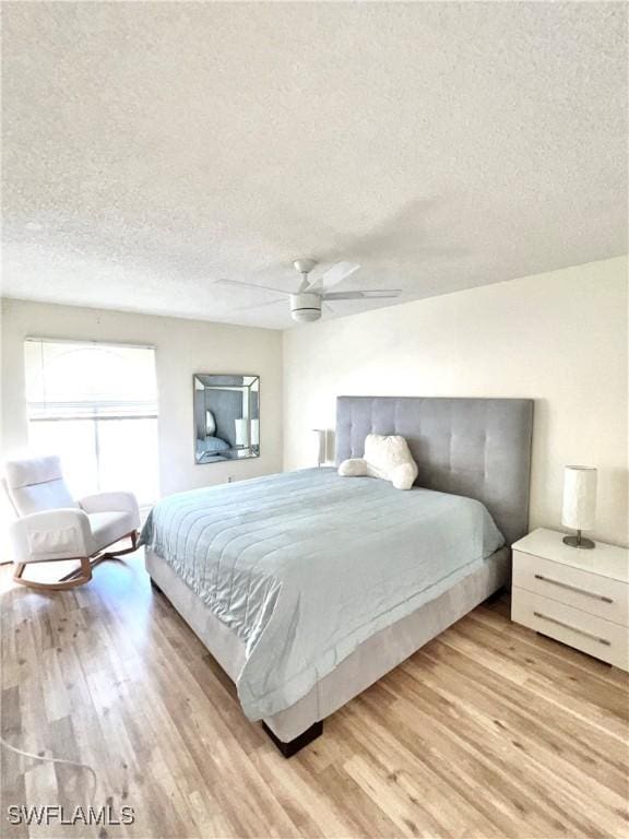 bedroom featuring a textured ceiling, light hardwood / wood-style flooring, and ceiling fan