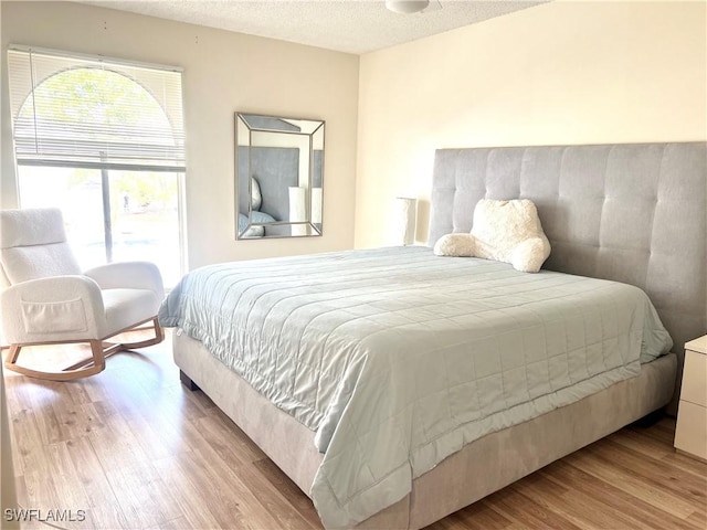 bedroom featuring a textured ceiling and light hardwood / wood-style flooring