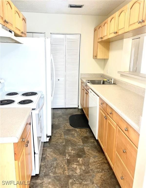 kitchen with light brown cabinets, white appliances, a textured ceiling, and sink