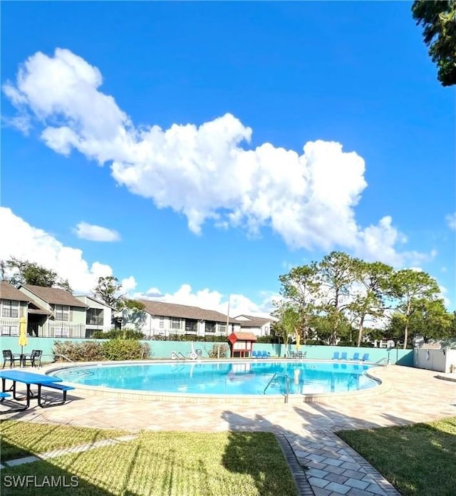 view of swimming pool with a patio area and a yard