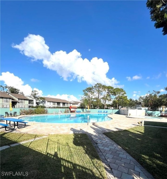 view of swimming pool featuring a lawn and a patio area