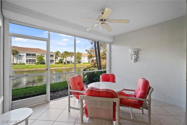 sunroom featuring a water view and ceiling fan