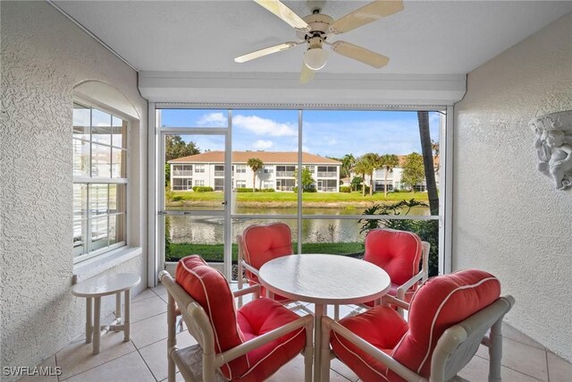 sunroom with a water view and ceiling fan