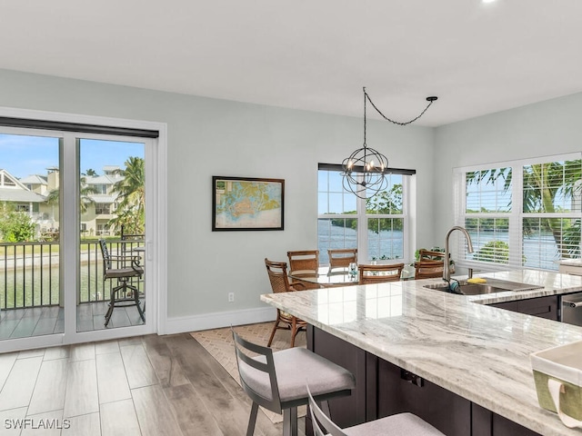 kitchen with sink, a water view, pendant lighting, and plenty of natural light