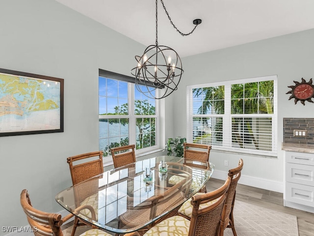 dining area featuring a notable chandelier, light hardwood / wood-style floors, and a wealth of natural light