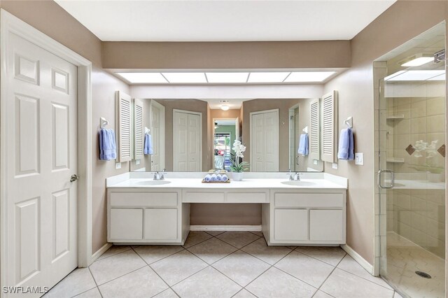 bathroom with tile patterned floors, a shower with door, and vanity