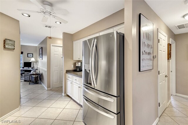 kitchen featuring white cabinetry, light tile patterned floors, and stainless steel refrigerator with ice dispenser