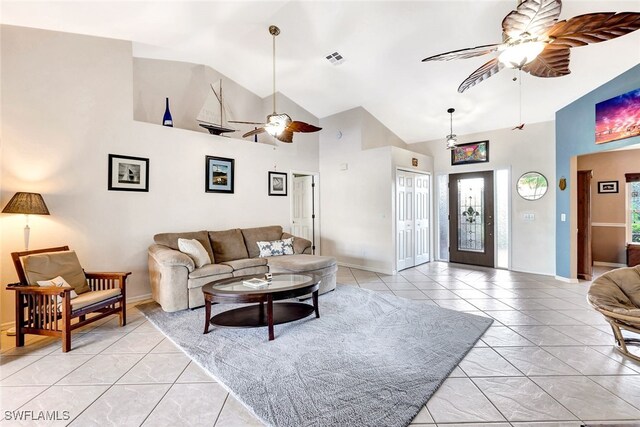 tiled living room with plenty of natural light, ceiling fan, and high vaulted ceiling