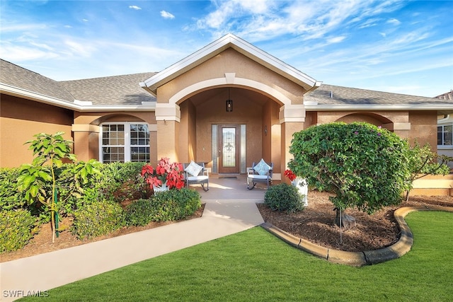 view of exterior entry featuring a lawn