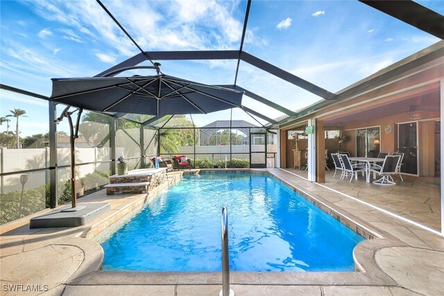 view of swimming pool with pool water feature, a lanai, and a patio area