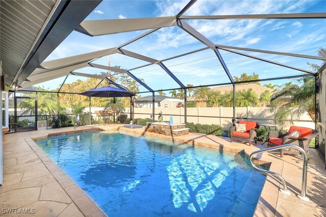 view of pool with glass enclosure and a patio