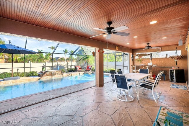 view of pool with pool water feature, a patio, area for grilling, and ceiling fan