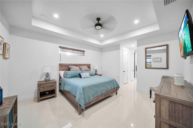 bedroom featuring a tray ceiling, ceiling fan, and light tile patterned floors