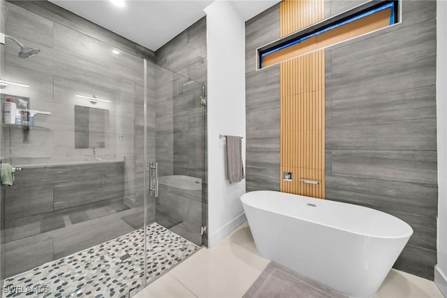 bathroom featuring tile patterned floors, tile walls, and independent shower and bath