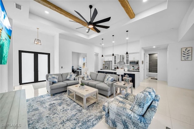 tiled living room with a tray ceiling, ceiling fan, a towering ceiling, and beam ceiling