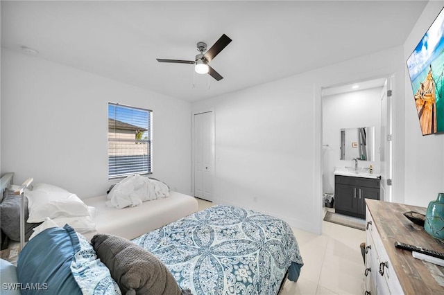 bedroom featuring ceiling fan, sink, light tile patterned floors, connected bathroom, and a closet