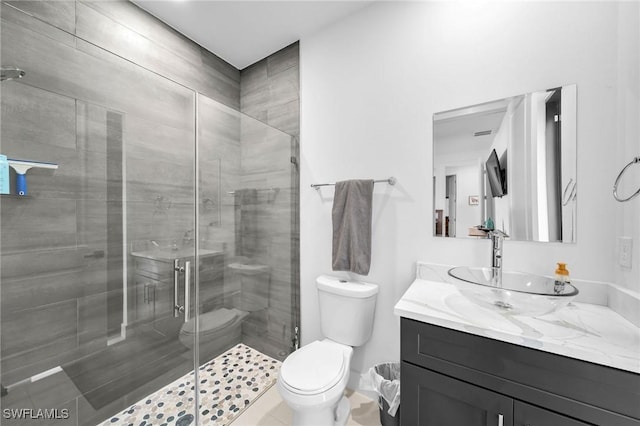 bathroom featuring an enclosed shower, vanity, toilet, and tile patterned floors