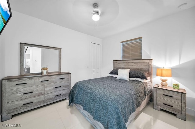 bedroom with light tile patterned floors, a closet, and ceiling fan