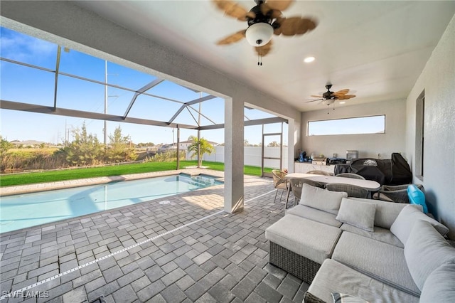 view of pool with glass enclosure, ceiling fan, a patio area, and an outdoor hangout area