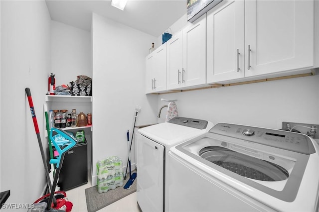 laundry area featuring washer and clothes dryer and cabinets