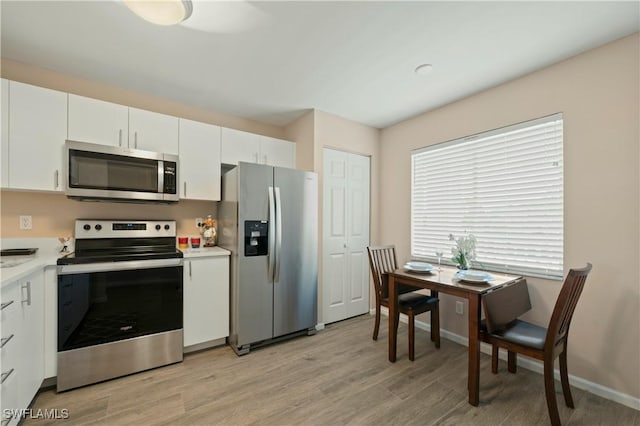 kitchen featuring white cabinetry, light hardwood / wood-style flooring, and appliances with stainless steel finishes