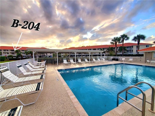 1051 Eastham Way Unit B-204, Naples, FL 34104 - pool at dusk featuring a community pool and a patio