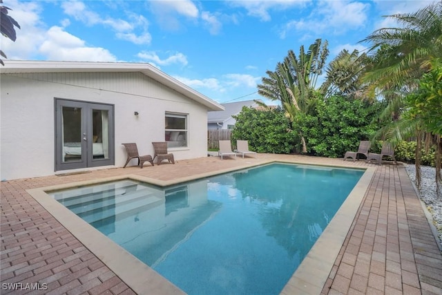 view of swimming pool with french doors and a patio