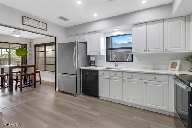 kitchen with dishwasher, white cabinets, sink, tasteful backsplash, and stainless steel refrigerator