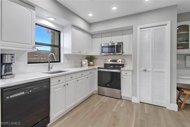 kitchen with decorative backsplash, appliances with stainless steel finishes, white cabinetry, and sink