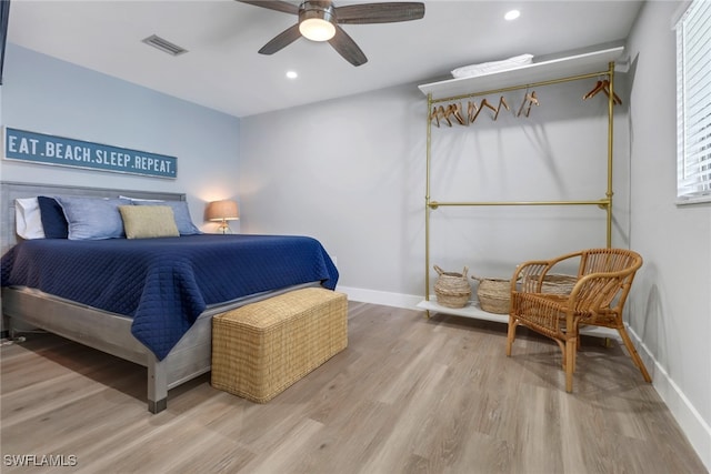 bedroom with multiple windows, ceiling fan, and light hardwood / wood-style floors