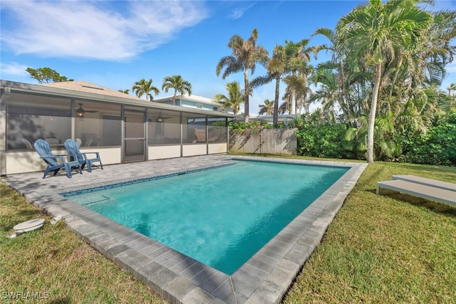 view of pool featuring a sunroom, ceiling fan, and a yard