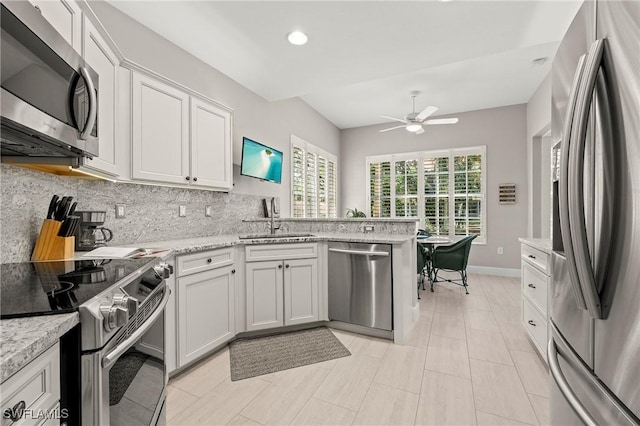 kitchen featuring decorative backsplash, sink, white cabinetry, and stainless steel appliances