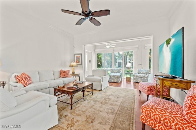 living room with light wood-type flooring, ceiling fan, and ornamental molding