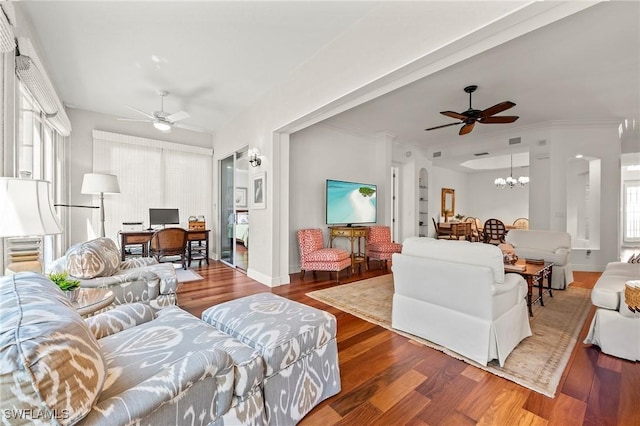 living room with crown molding, ceiling fan with notable chandelier, and hardwood / wood-style flooring