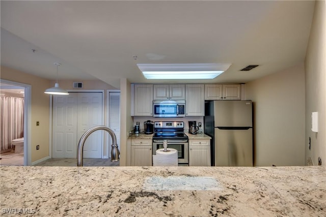 kitchen with visible vents, stainless steel appliances, decorative light fixtures, and baseboards