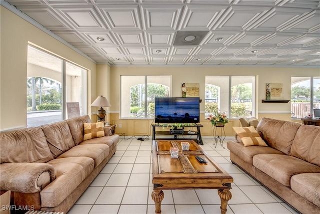 living room with a healthy amount of sunlight, light tile patterned floors, and an ornate ceiling