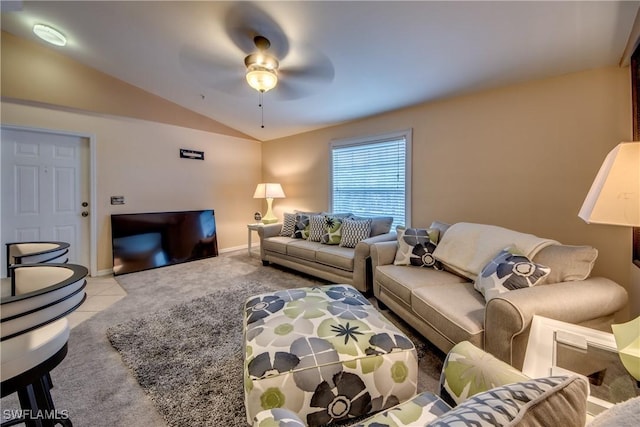 living area with light tile patterned floors, light colored carpet, vaulted ceiling, and ceiling fan